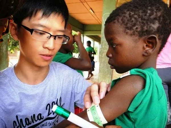 Alwin, a volunteer from Hong Kong University, measuring a child's weight and height on the Moringa programme, 2012